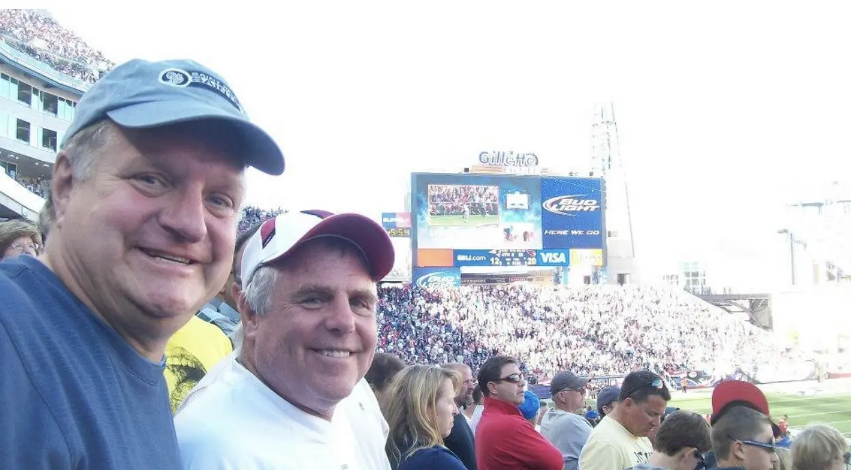 Two men smiling in crowded baseball stadium