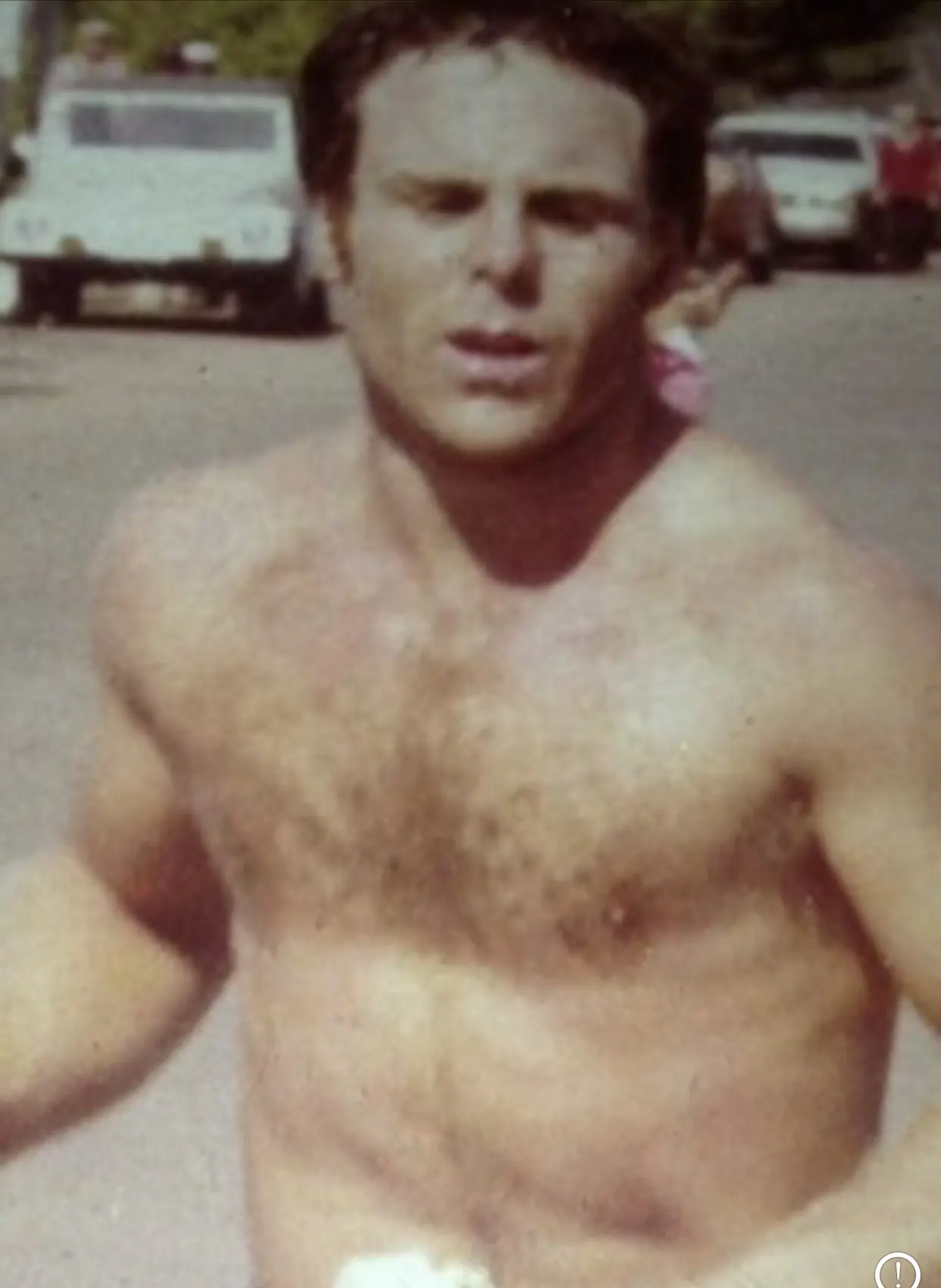 Shirtless runner on sunlit neighborhood street