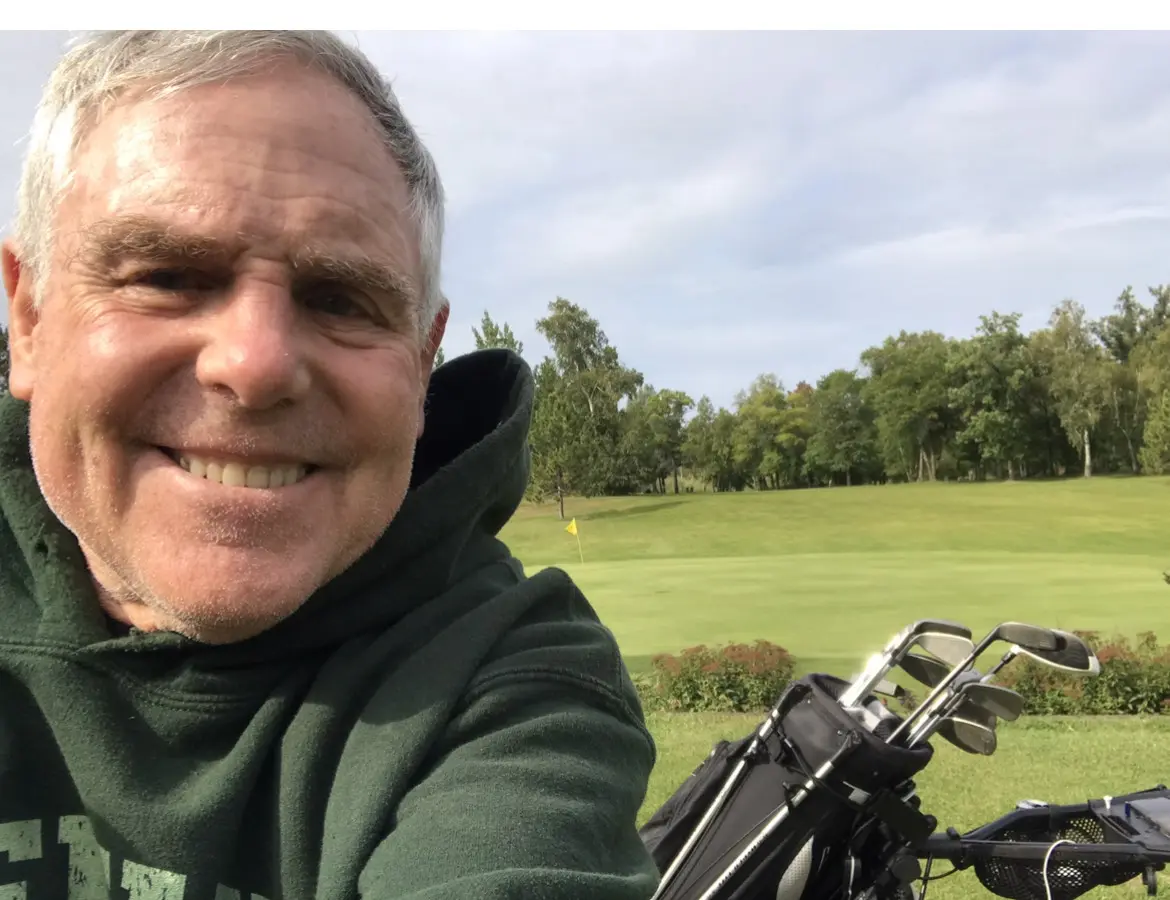 Smiling man taking selfie on golf course