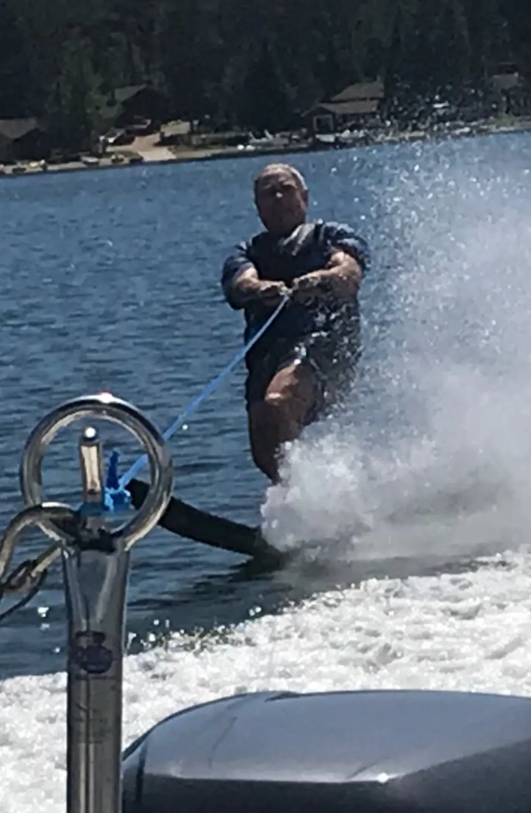 Man waterskiing on lake behind boat