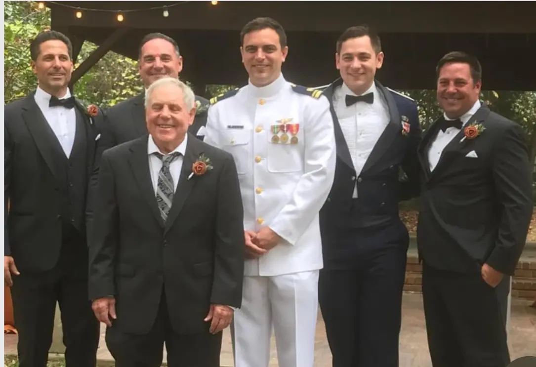 Man in white naval uniform with groomsmen