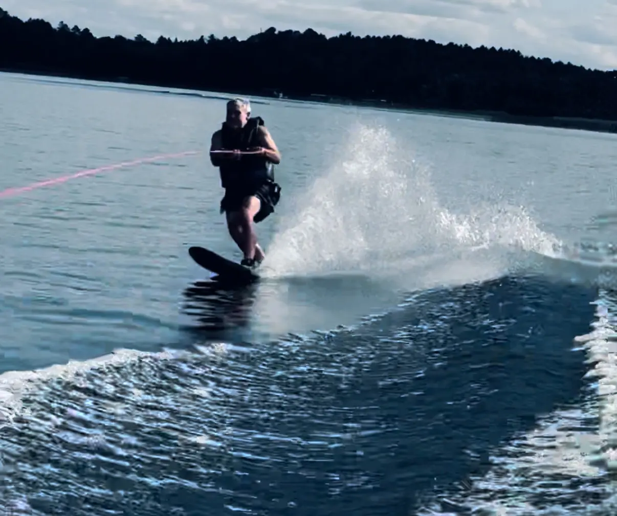 Wakeboarder carving through wake on lake