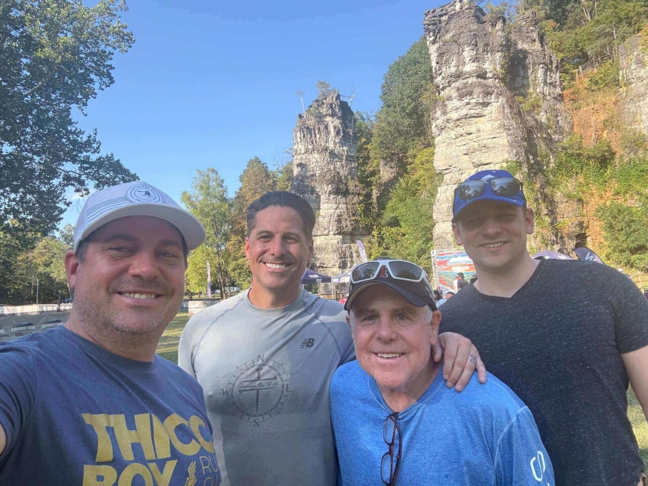 Four smiling men by towering limestone rock formations